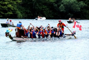 Dragon boat in a race with Justin at back steering